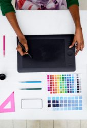 Top view of hands of designer during work with wacom and stylus